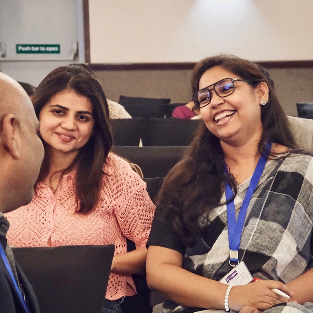 Non-clinical Art Therapist networking and laughing with two other mental health professionals during a break at the Indian Mental Health Summit.